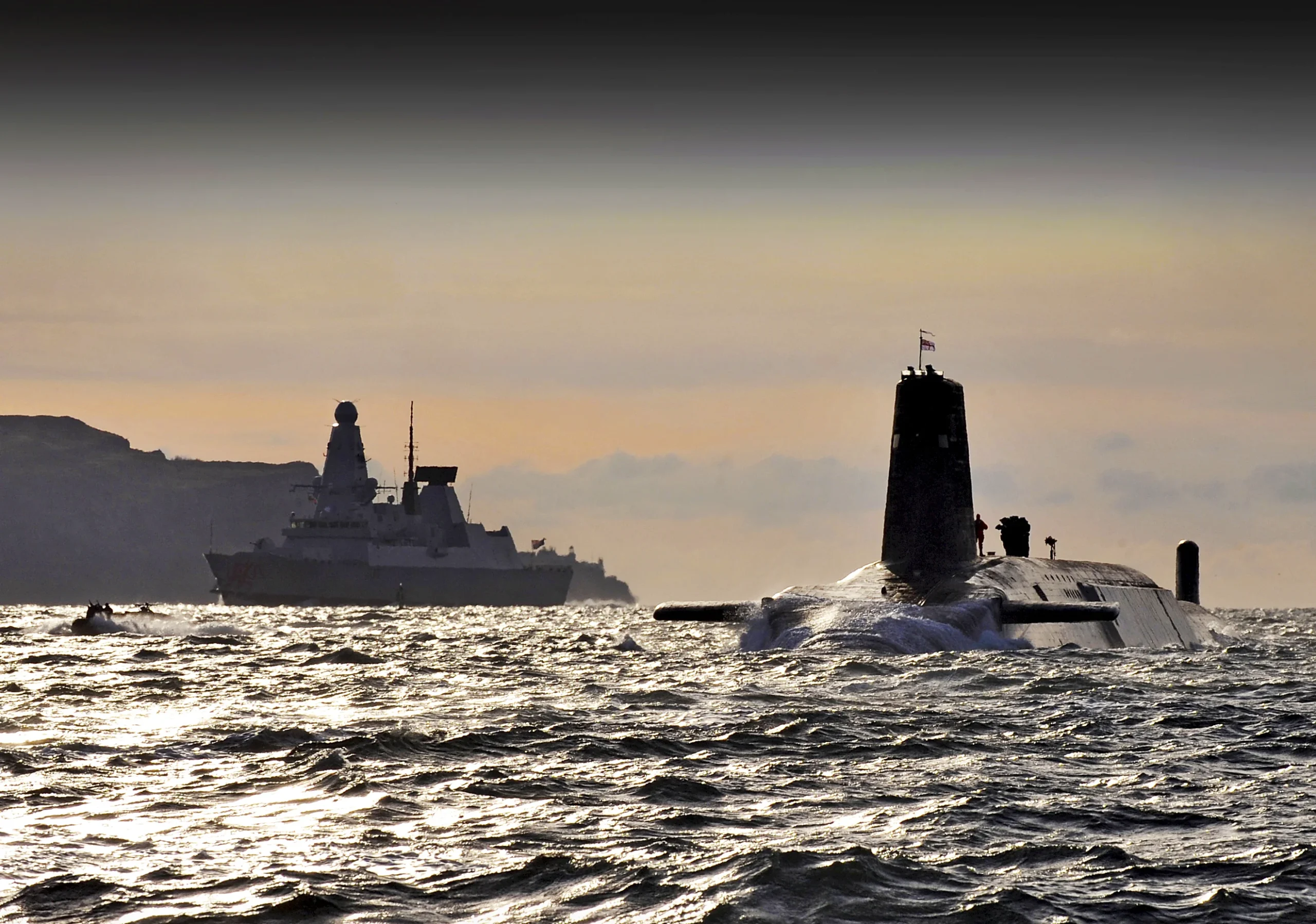 A submarine emerges near a surface ship, highlighting the coexistence of different types of vessels and their strategic capabilities.